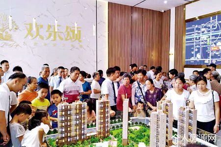 購房者在永堅歡樂頌的沙盤前看房